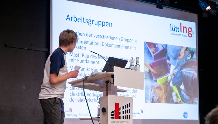 Ein Jugendlicher hält eine Lütt Ing Powerpoint-Präsentation