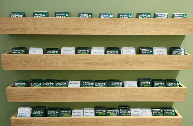 Grüne Wand mit Holzfächern gefüllt mit Saatguttütchen